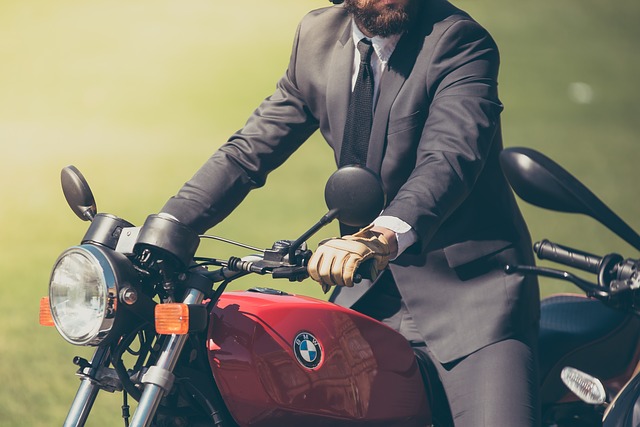 Muž v obleku sedí na motorke